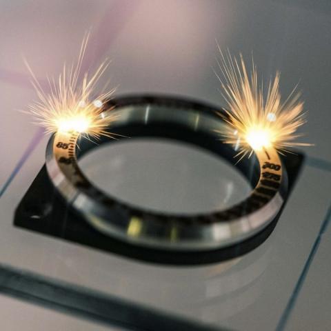 Photographie montrant le gravage d'une lunette, et son cortège d'étincelles.